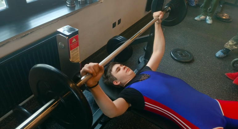 На фото: Василий Филичкин лежит со штангой.